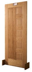 A vertical panel solid wood interior door in natural finish, standing upright against a white background